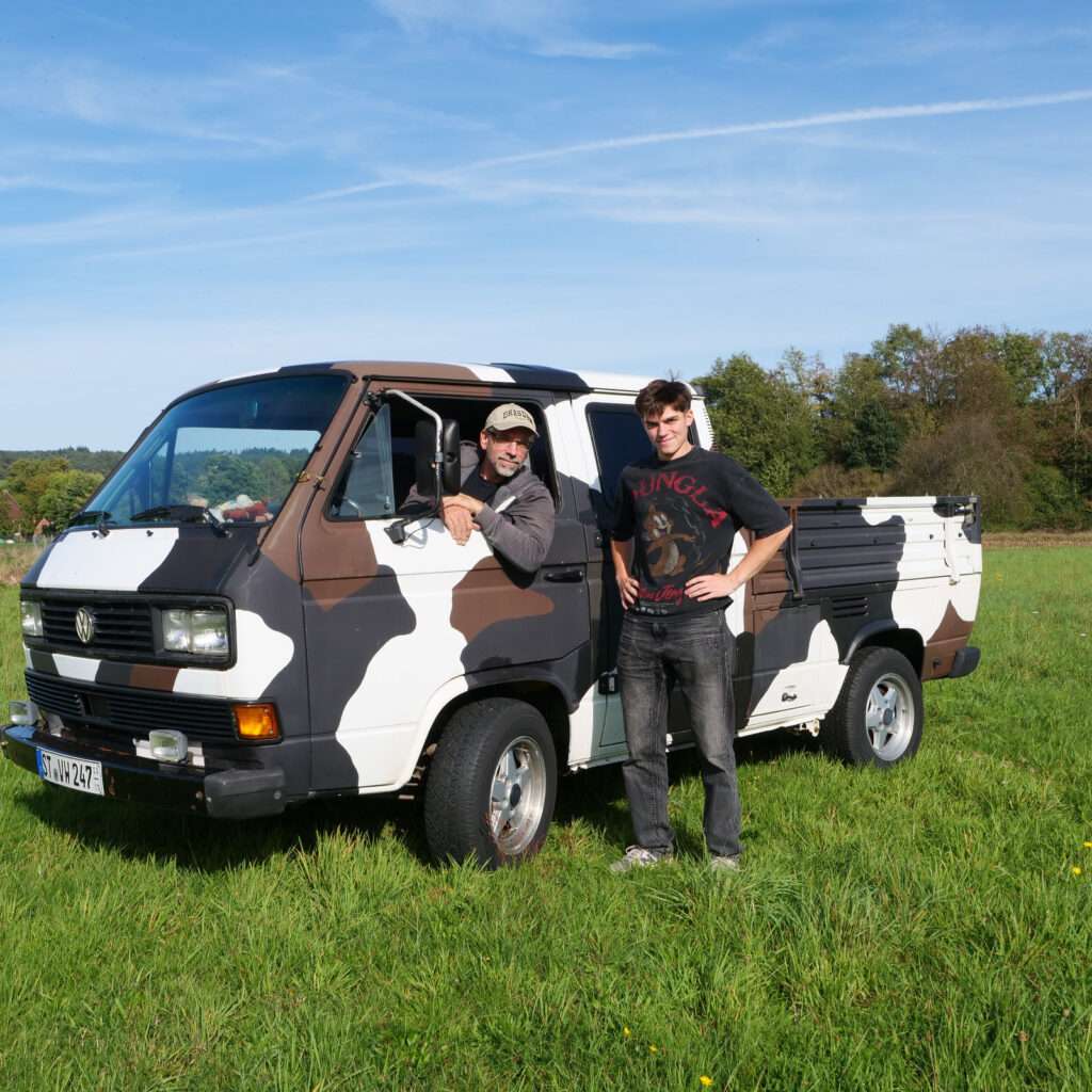 Das Schneider-Teile Team mit dem T3 Doka auf der Wiese